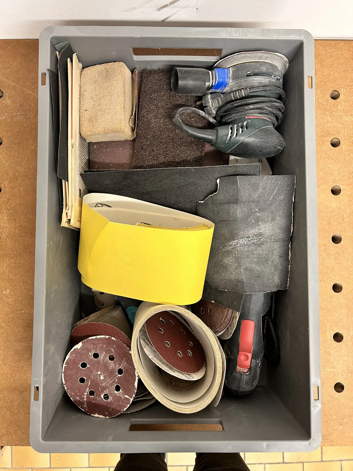 Euro container photographed from above: sandpaper and sander